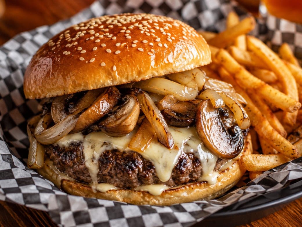 The Mushroom Swiss Burger with grilled mushrooms, grilled onions and swiss cheese, served with fries.