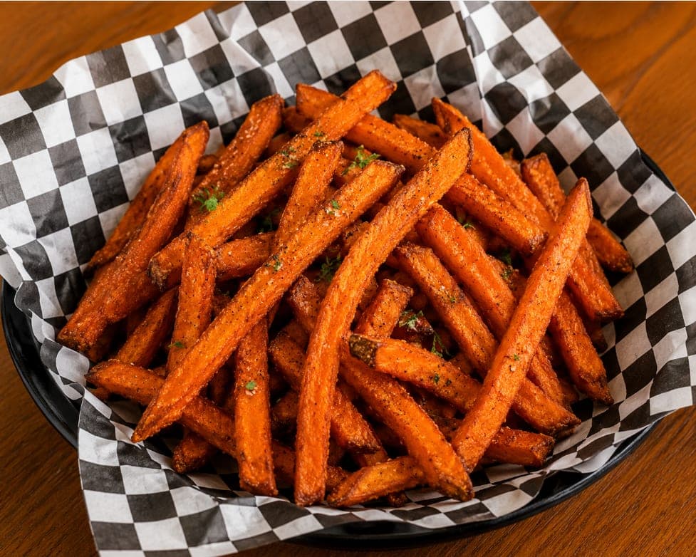A basket of seasoned sweet potato fries.