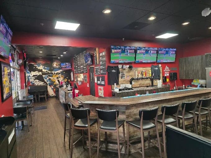 The bar with stools, taps and TVs showing the game.