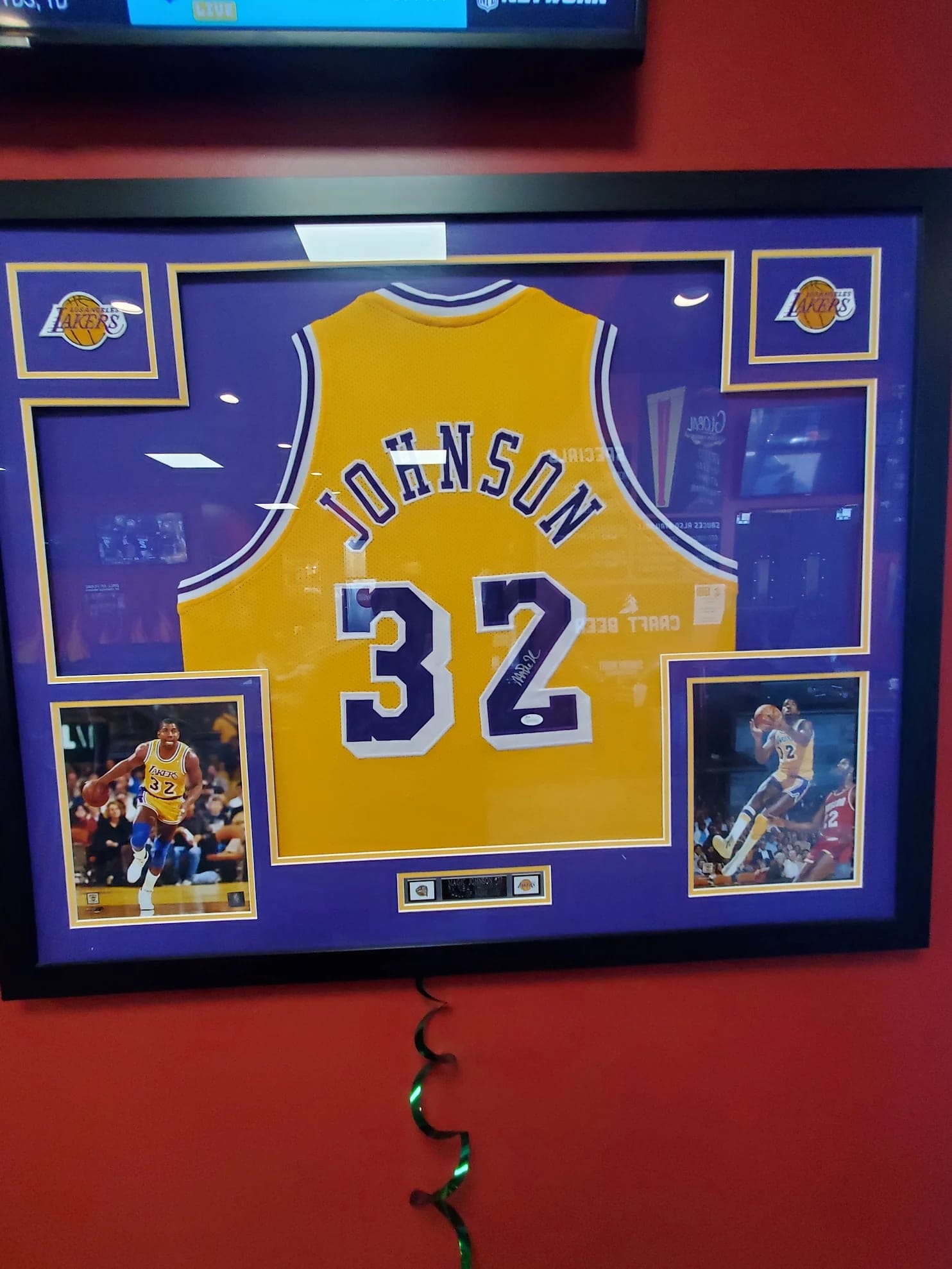 A signed Magic Johnson Lakers jersey framed on the dining room wall.